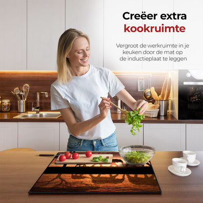 Vrouw in de keuken bezig met eten voorbereiden met behulp van de inductie beschermer olifanten